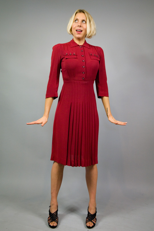 model wearing a 1940s red military dress