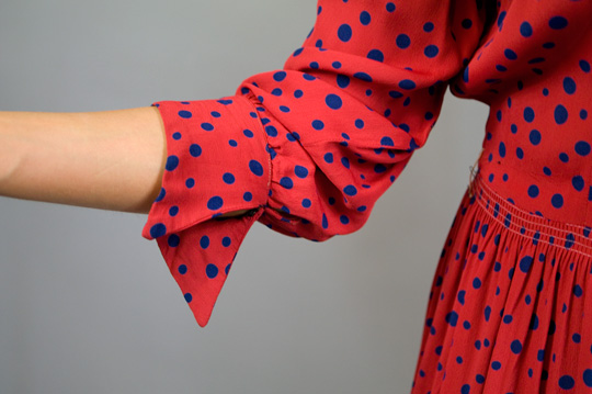 the sleeve and cuffs of a 1940s red polka dot rayon dress